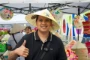 Man in conical hat smiles and gives thumbs-up.